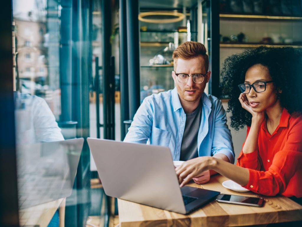 Two people working on laptop in coffeeshop