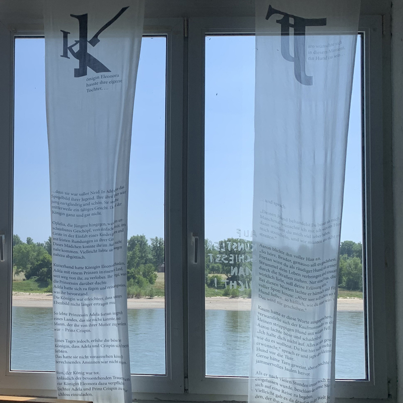 Seidenfahnen am Fenster – mit Blick auf den Rhein